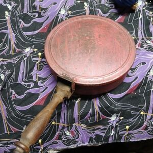 vintage copper frying pan with a wooden handle.